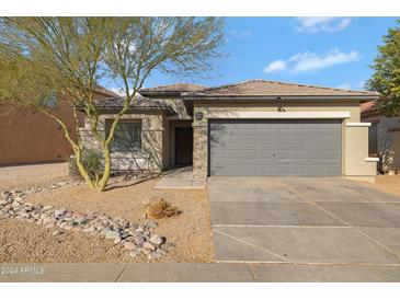 One-story house with gray garage door and rock landscaping at 9310 W Berkeley Rd, Phoenix, AZ 85037