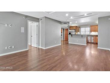 Living room with hardwood floors, kitchen view, and open floor plan at 16616 E Palisades Blvd # 102, Fountain Hills, AZ 85268