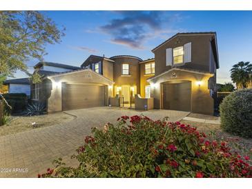 Two-story house with a three-car garage and landscaped front yard at dusk at 14575 W Orange Dr, Litchfield Park, AZ 85340