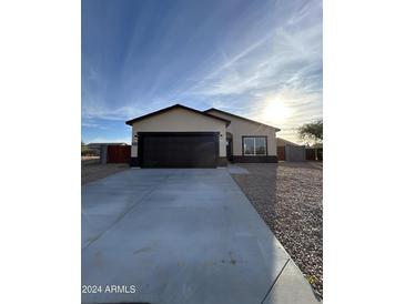 New construction home with a two-car garage and desert landscaping at 15494 S Kline Pl, Arizona City, AZ 85123