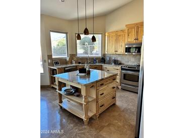 Bright kitchen with granite island, custom wood cabinetry, and stainless steel appliances at 8990 E Sonoran Way, Gold Canyon, AZ 85118