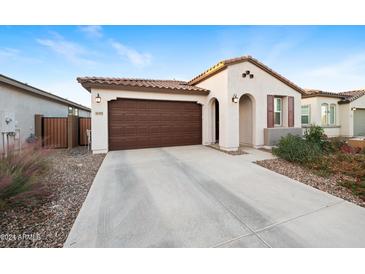 Single-story home with brown garage door and landscaped yard at 36595 W Mediterranean Way, Maricopa, AZ 85138