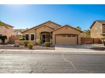 One-story house with tan exterior, two-car garage, and desert landscaping at 4081 E Dublin St, Gilbert, AZ 85295