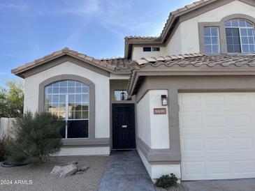 Front view of two-story house with a decorative door and walkway at 6891 W Via Del Sol Dr, Glendale, AZ 85310