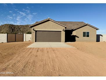 New single-story home with a two-car garage and desert landscaping at 8540 W Ginger Trl, Casa Grande, AZ 85194