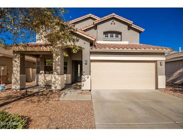 Two-story house with a beige colored garage door and landscaping at 10350 W Foothill Dr, Peoria, AZ 85383