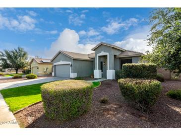 Gray house exterior with a two-car garage and neatly landscaped front yard at 13015 W Highland Ave, Litchfield Park, AZ 85340