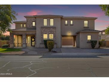 Two-story house with stone accents and a three-car garage at 20295 E Camina Plata --, Queen Creek, AZ 85142