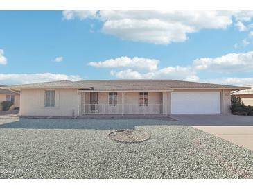 Ranch-style home with a two-car garage and a gravel front yard at 9725 W Pineaire Dr, Sun City, AZ 85351