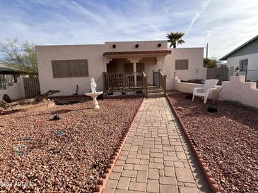 Cute stucco home with a landscaped front yard, walkway, and decorative fountain at 231 N Martin Ave, Gila Bend, AZ 85337