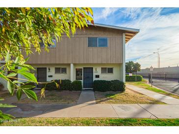 Tan two-story townhome with front yard landscaping and walkway at 2449 W Missouri Ave, Phoenix, AZ 85015