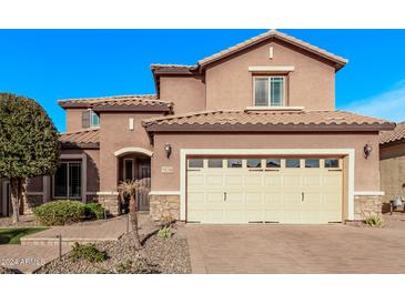 Two-story house with beige exterior, stone accents, and a three-car garage at 10746 W Desert Elm Ln, Peoria, AZ 85383