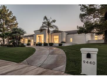 Stunning curb appeal with a long driveway, lush landscaping, and a grand entrance at 9440 N 57Th St, Paradise Valley, AZ 85253