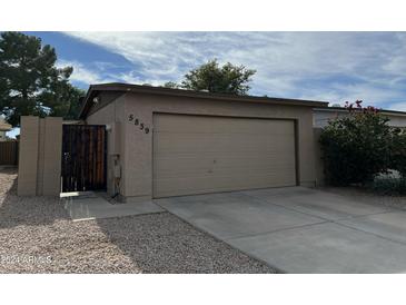 Tan colored garage with driveway and landscaping at 5839 E Norwood St, Mesa, AZ 85215