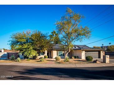House exterior showcasing a wide street and mature trees surrounding the property at 10601 N 26Th Pl, Phoenix, AZ 85028