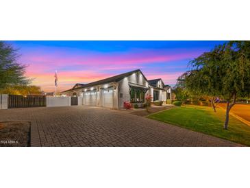 Stunning curb appeal featuring a charming farmhouse exterior, a paved driveway, and lush landscaping at 17870 E Appaloosa Dr, Queen Creek, AZ 85142