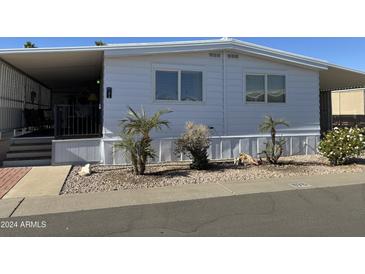 White single-wide manufactured home with covered porch and landscaping at 4065 E University Dr # 373, Mesa, AZ 85205