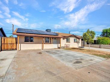 Ranch style home with solar panels and a spacious driveway at 6826 W Pierson St, Phoenix, AZ 85033