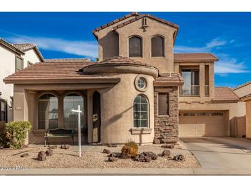 Two-story house with tan exterior, stone accents, and a two-car garage at 1306 S Normandy --, Mesa, AZ 85209