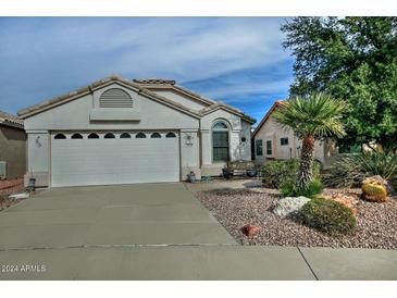 Single-story home with a two-car garage and landscaped front yard at 18048 W Spencer Dr, Surprise, AZ 85374