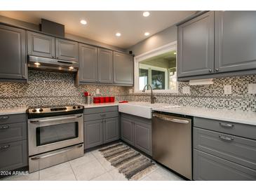 Modern kitchen with stainless steel appliances and white sink at 18435 N 125Th Ave, Sun City West, AZ 85375