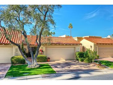 Spanish style home with tile roof, attached garage, and mature landscaping at 10050 E Mountainview Lake Dr # 69, Scottsdale, AZ 85258