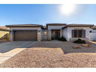 Single-story home with a two-car garage and desert landscaping at 21171 E Stirrup St, Queen Creek, AZ 85142