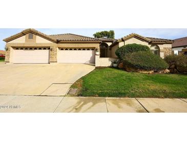 Beautiful home with three-car garage and well-manicured lawn at 7032 W Aurora Dr, Glendale, AZ 85308