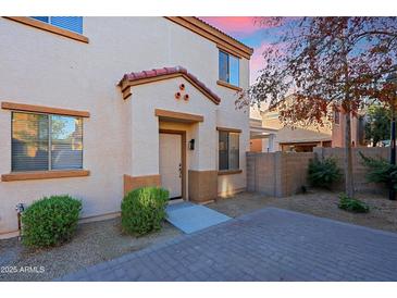 Tan two-story home with front door and landscaping at 7519 S 13Th Pl, Phoenix, AZ 85042