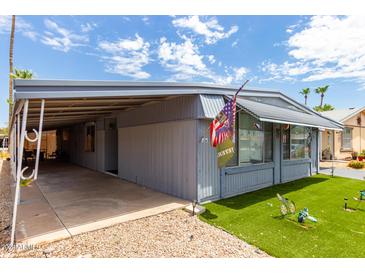 Mobile home with carport and landscaped lawn at 6828 W Pierce St # 126, Phoenix, AZ 85043