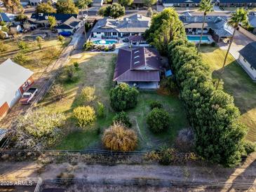 Aerial view showing a large house, pool, and expansive backyard with mature trees at 1440 E Secretariat Dr, Tempe, AZ 85284