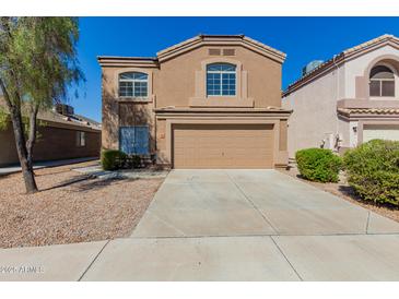 Two-story house with tan exterior, two-car garage, and landscaping at 14804 N 129Th Dr, El Mirage, AZ 85335