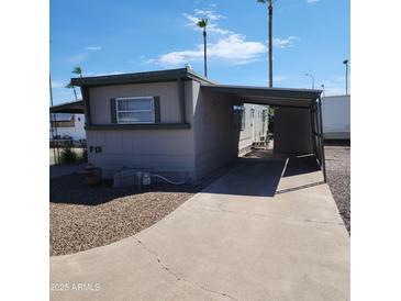 Mobile home with carport and paved driveway at 2460 E Main E St # F13, Mesa, AZ 85213