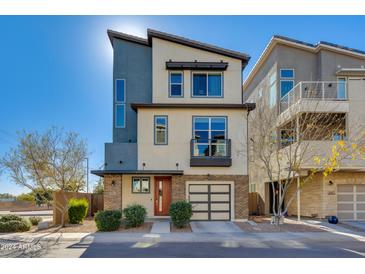 Modern three-story home with attached two-car garage and attractive landscaping at 7031 W Jasper Dr, Chandler, AZ 85226