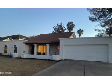 White single story home with a red tile roof, two-car garage, and landscaping at 1745 E Glade Ave, Mesa, AZ 85204