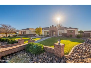 Beautiful ranch home with brick accents and a lush, manicured lawn at 21391 E Orchard Ln, Queen Creek, AZ 85142