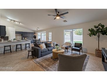 Spacious living room with vaulted ceiling, stylish furniture, and backyard view at 3754 E Baranca Ct, Gilbert, AZ 85297