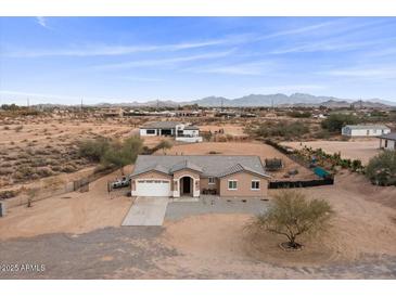 Aerial view of a single-story house with a large backyard and mountain views at 12121 S 214Th Ave, Buckeye, AZ 85326