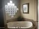 Relaxing bathroom with corner jacuzzi tub, granite vanity, and a glass block window at 10100 N 78Th Pl, Scottsdale, AZ 85258