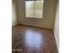 Well-lit bedroom with wood-look flooring and window blinds at 10100 N 78Th Pl, Scottsdale, AZ 85258