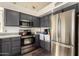Modern kitchen features stainless steel appliances and dark gray cabinetry at 7233 W Corrine Dr, Peoria, AZ 85381