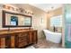 Bathroom with copper vanity, a large soaking tub, and glass block window at 29202 N 146Th St, Scottsdale, AZ 85262