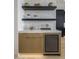 Wet bar with floating shelves, wine cooler, and marble backsplash at 37200 N Cave Creek Rd # 2120, Scottsdale, AZ 85262