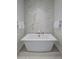Luxurious bathroom with a freestanding soaking tub and marble feature wall at 37200 N Cave Creek Rd # 2120, Scottsdale, AZ 85262
