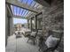 Covered patio features a stone wall, comfortable seating, and a pergola at 37200 N Cave Creek Rd # 2120, Scottsdale, AZ 85262