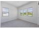 Bright bedroom with neutral carpeting and multiple windows at 7583 W Gelding Dr, Peoria, AZ 85381
