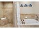 Spa-like bathroom with soaking tub, shower, and tiled walls at 7120 N Clearwater Pkwy, Paradise Valley, AZ 85253