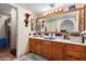 Bathroom with double sinks, a large mirror, and a shower at 2 E Muriel Dr, Phoenix, AZ 85022