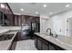 Modern kitchen with dark wood cabinets, granite counters, and island at 42151 W Somerset Dr, Maricopa, AZ 85138