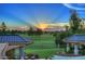 Sunset view of backyard oasis with golf course views and patio furniture at 15 Biltmore Estates Dr, Phoenix, AZ 85016